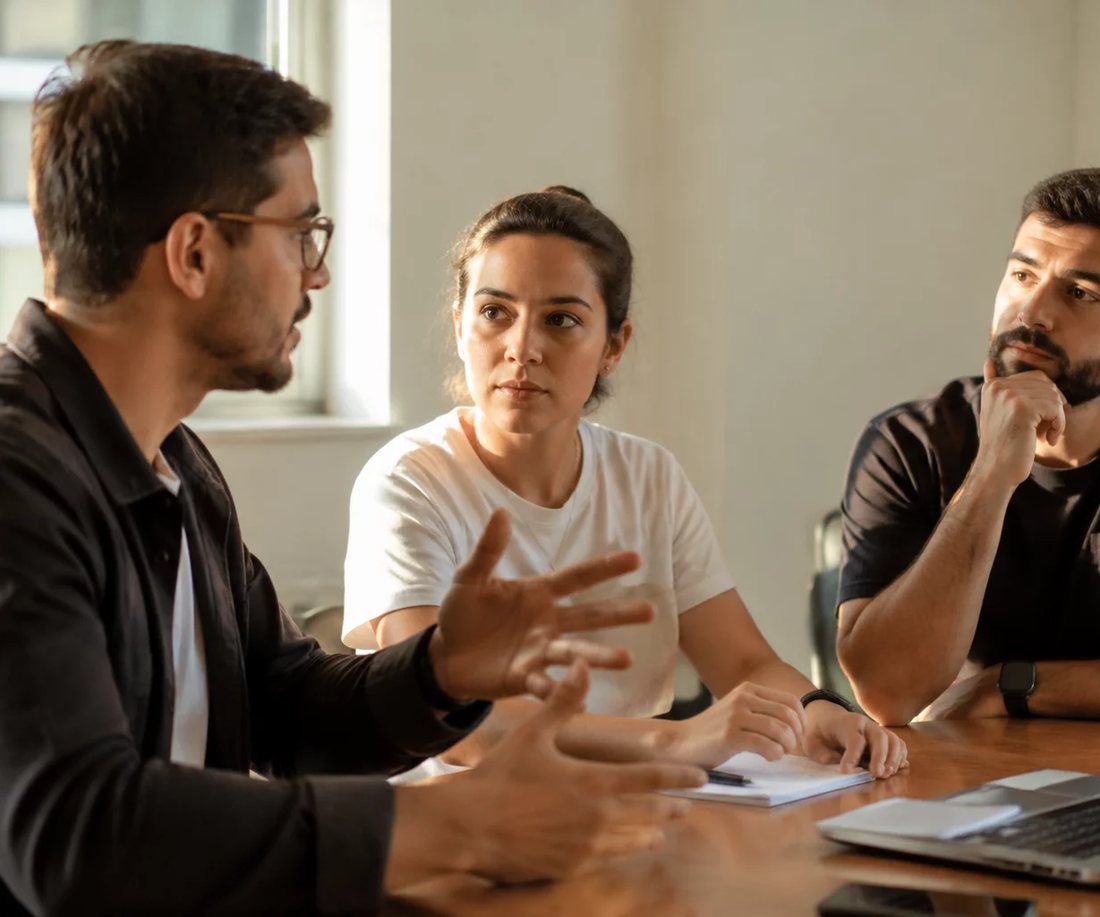 Participantes conversando de pé entre as estantes, minutos antes de o encontro começar